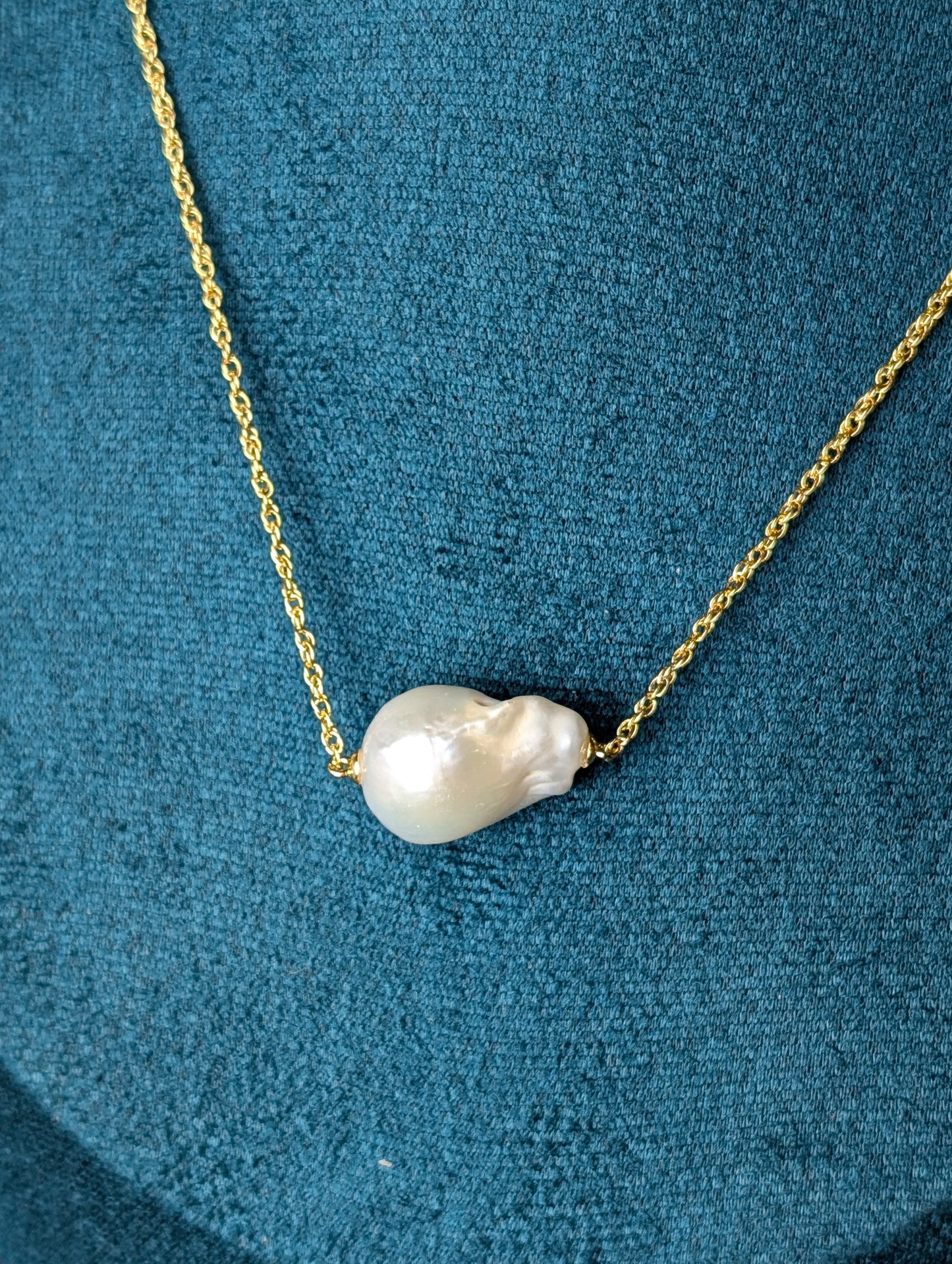 Nacre Necklace by Nudie – close-up studio photo highlighting the irregular baroque freshwater pearl pendant on a hammered 18k gold-plated chain.