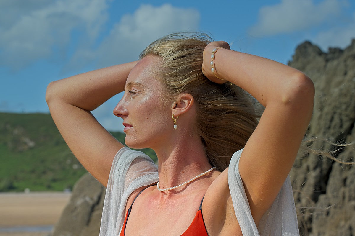 Woman with hands in hair against a scenic background