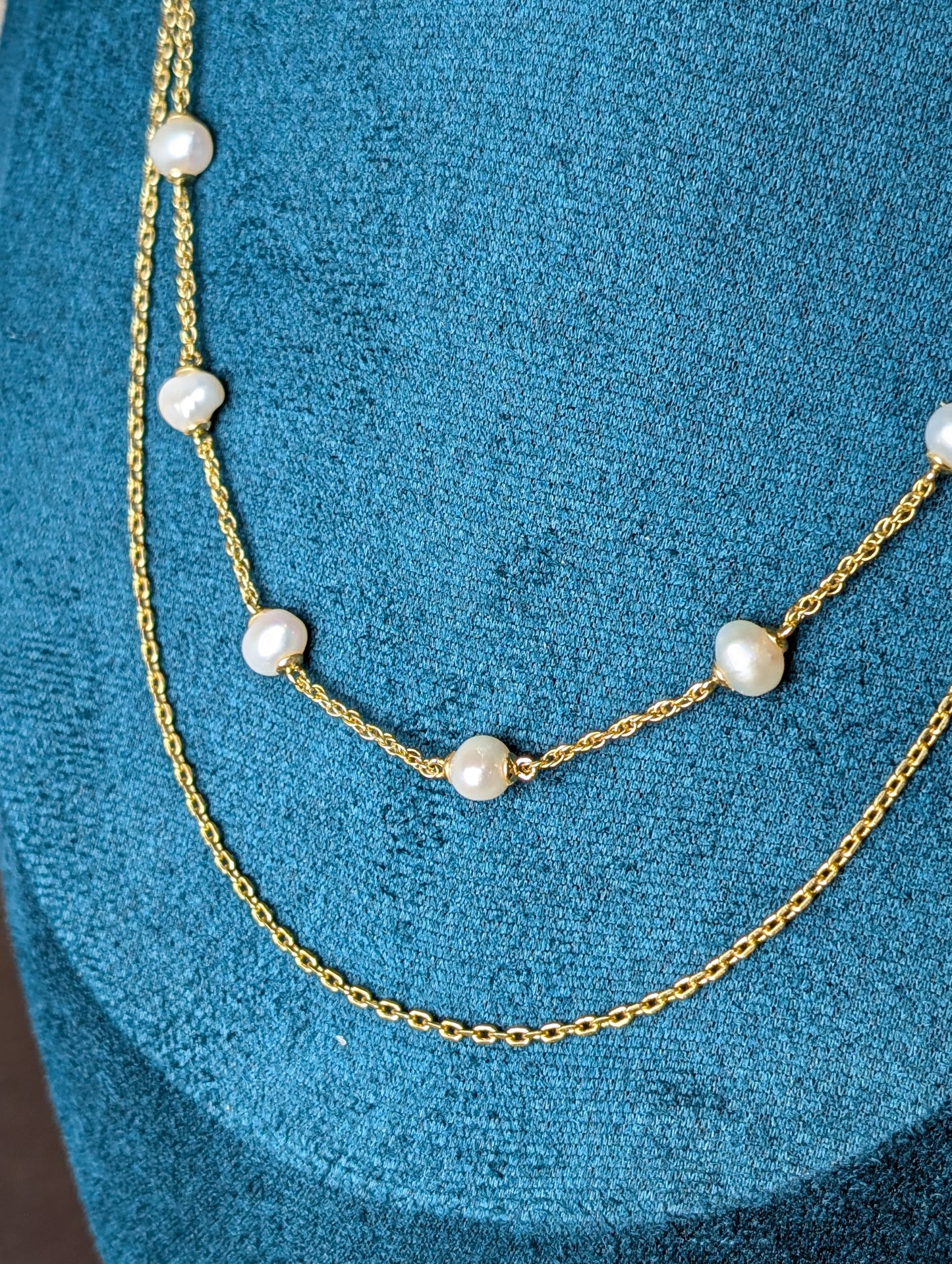 Maris Necklace by Nudie – close-up studio photo highlighting the freshwater pearls on a delicate gold chain, with twisted chain detail and hammered gold accents.