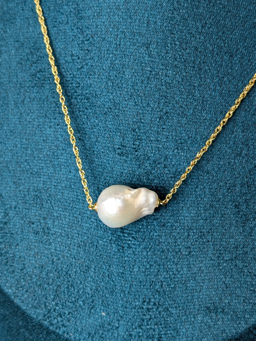 Nacre Necklace by Nudie – close-up studio photo highlighting the irregular baroque freshwater pearl pendant on a hammered 18k gold-plated chain.