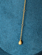Nudie Kiss by Nudie – close-up studio photo showing the signature counterweight at the back of the necklace, resting against a green mannequin background.