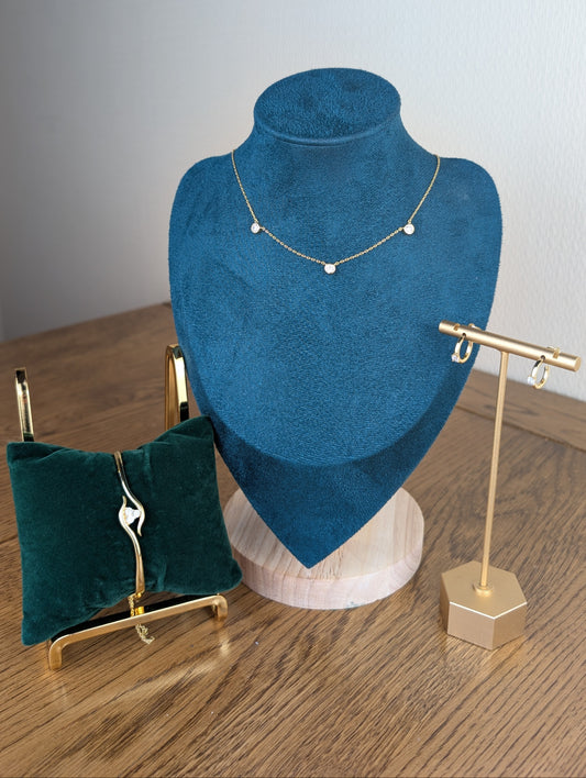 Jewelry display with necklace on blue velvet bust and earrings on stands.