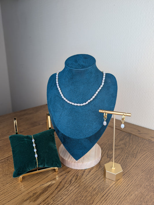 Jewelry set including a necklace, earrings, and a ring on stands against a plain background.