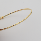 Nacre Bangle by Nudie – close-up studio photo on white background showing the hammered 18k gold-plated texture in detail.