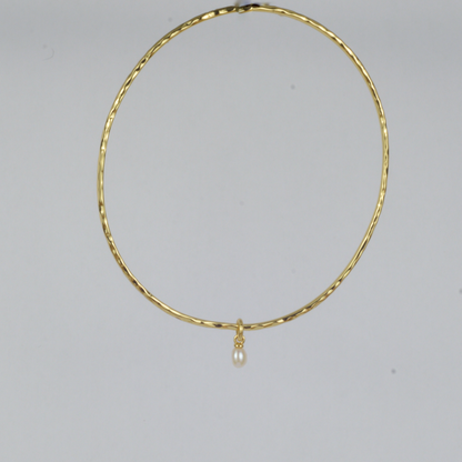 Nacre Bangle by Nudie – studio photo on white background showing the bangle hanging front-on to the camera, highlighting its sculpted shape and pearl detail.