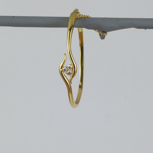 Avalon Bangle by Nudie – studio photo showing the open gold bangle hanging upright, featuring textured 18k gold and a single sparkling crystal accent.