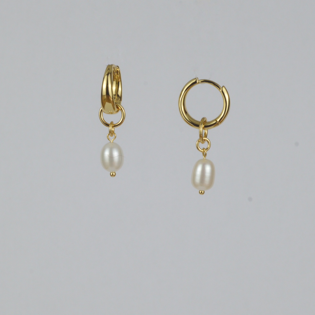 Perla Earrings by Nudie – studio photo showing one teardrop freshwater pearl earring front-on and one side-on, on white background with 18k gold hooks.