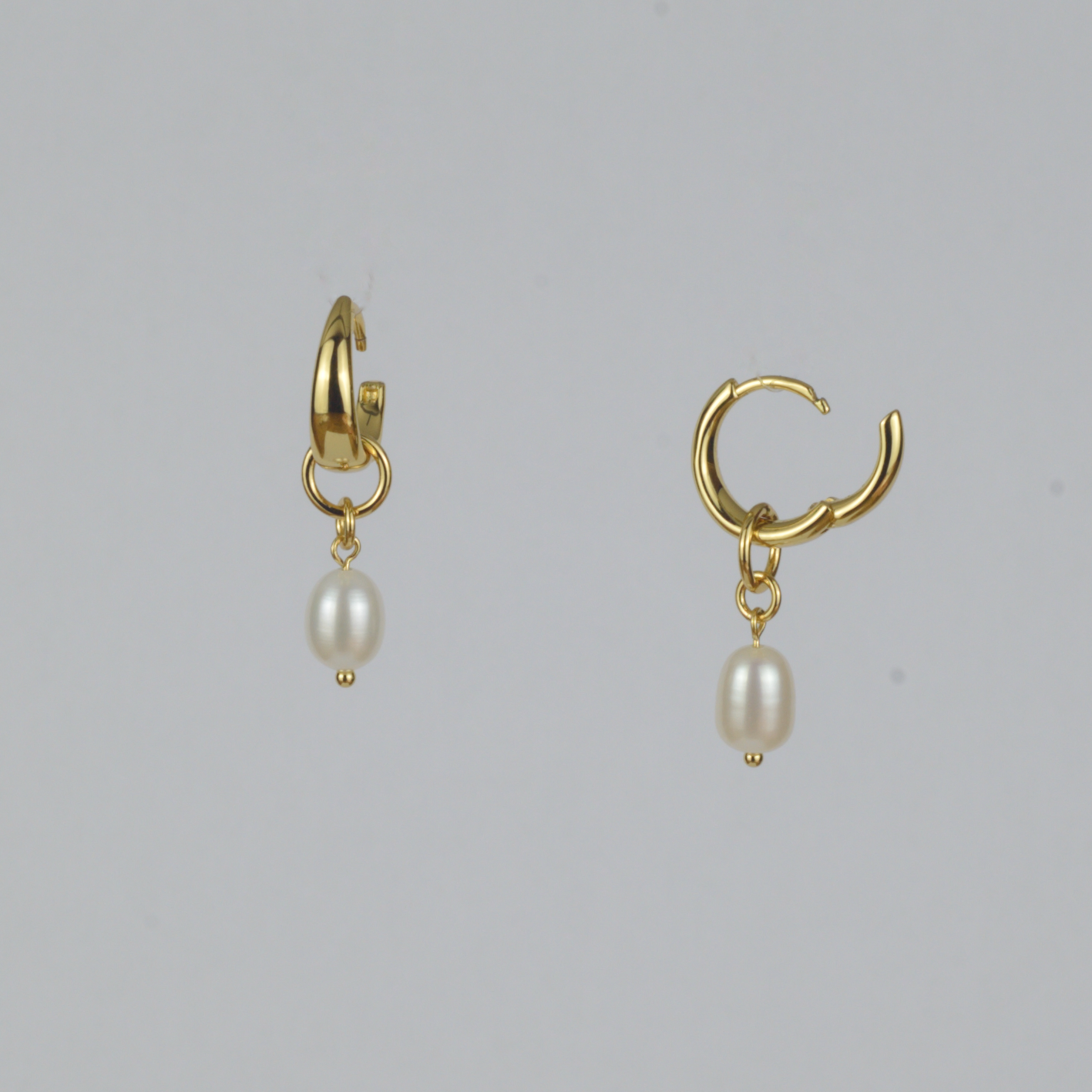 Perla Earrings by Nudie – studio photo with one earring front-on and one side-on, open to show the click closure, on white background with freshwater pearl drop.