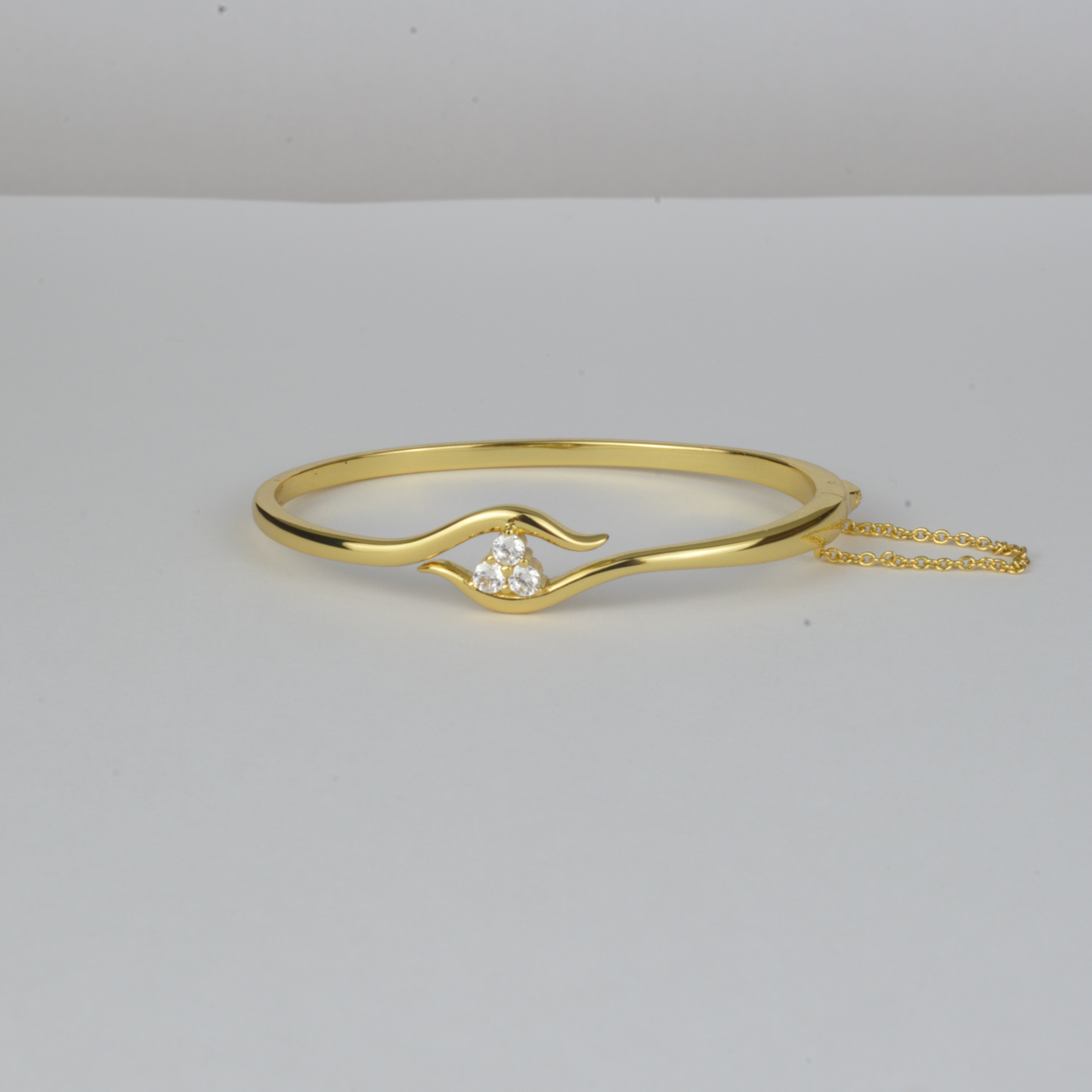 Avalon Bangle by Nudie – studio photo on white background showing the open bangle laid flat, with hammered gold finish and crystal detail at one end.