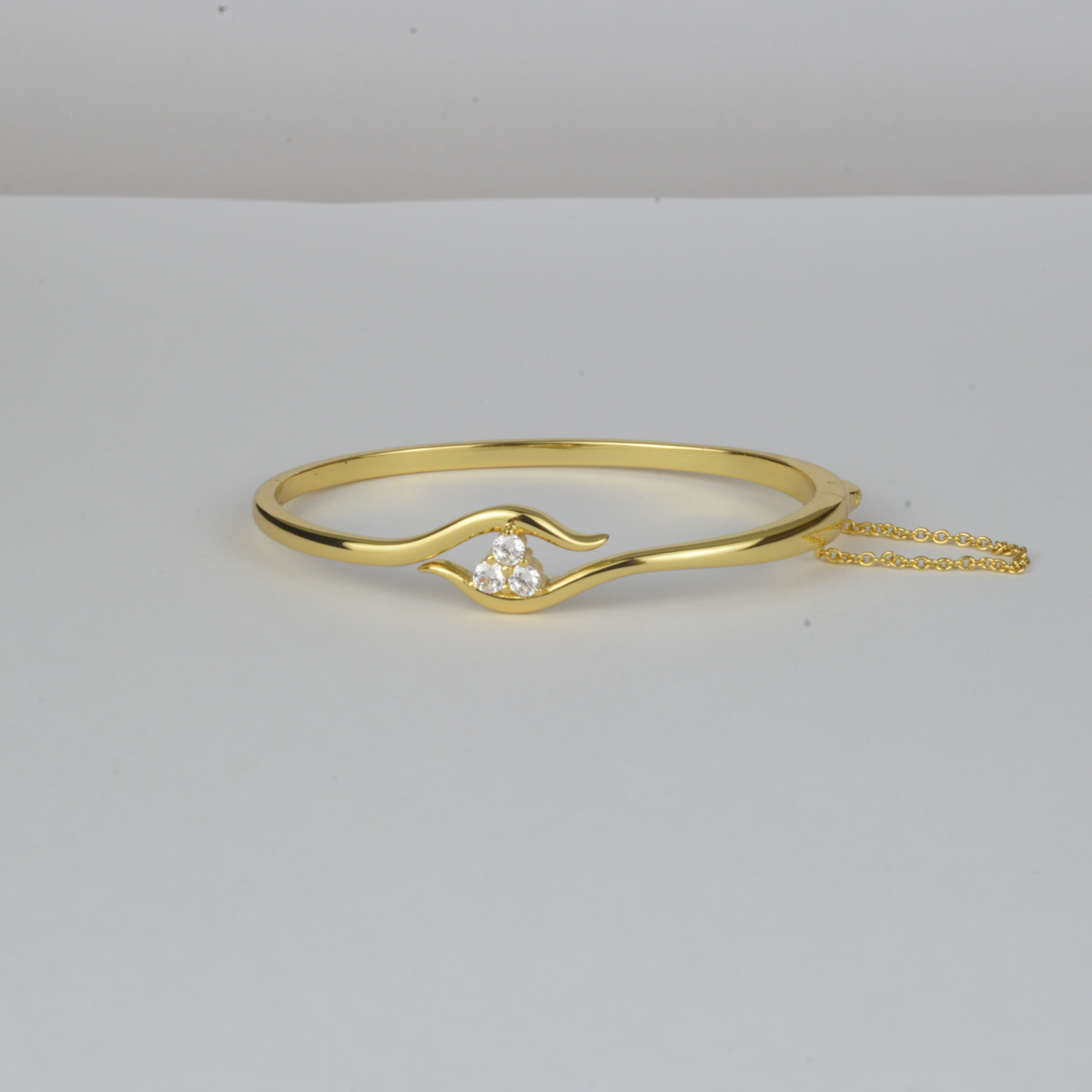 Avalon Bangle by Nudie – studio photo on white background showing the open bangle laid flat, with hammered gold finish and crystal detail at one end.