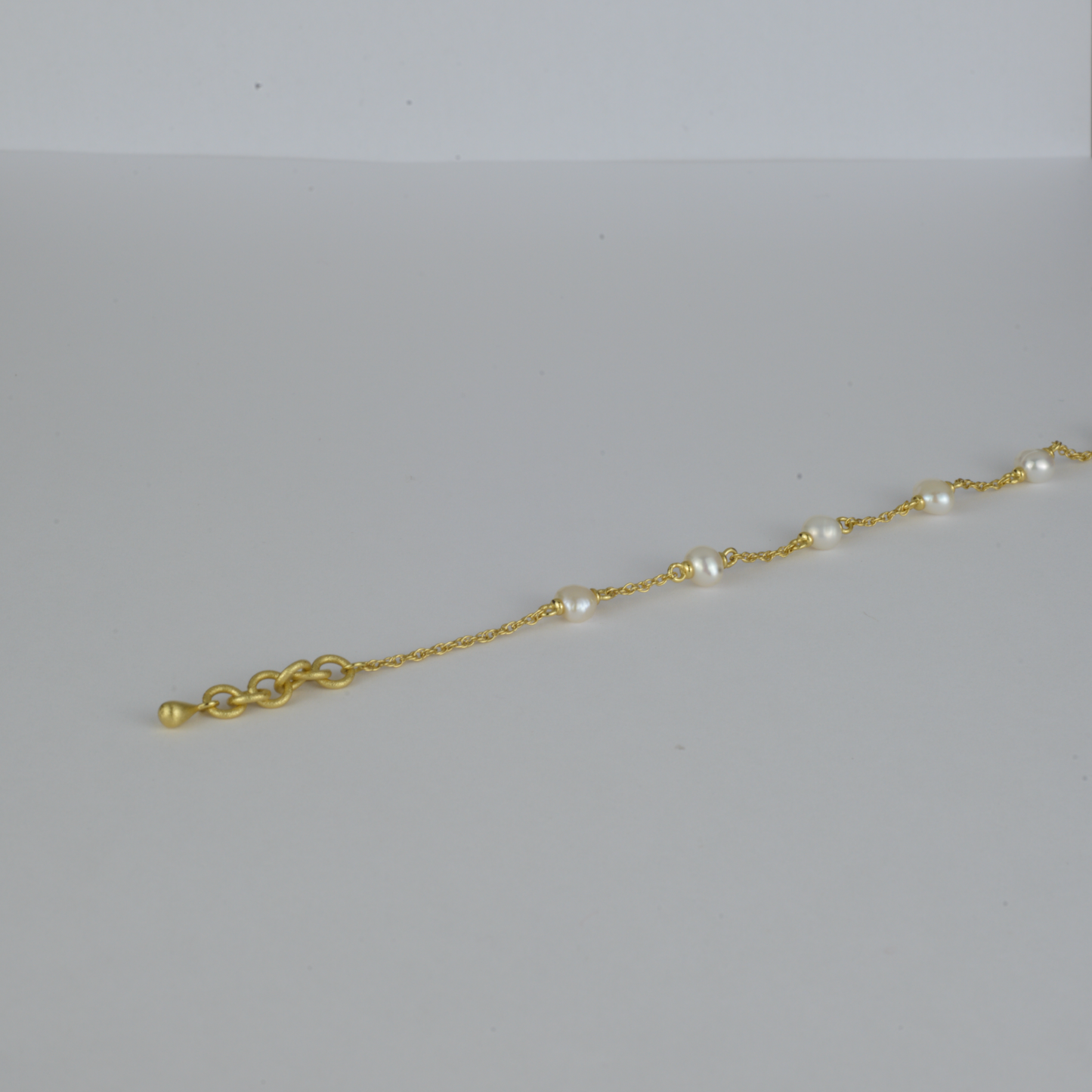 Maris Bracelet by Nudie – studio photo on white background showing the end of the chain with brushed gold hoops and delicate 18k gold-plated finish.